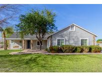 Charming single-story home featuring a well-manicured lawn, stone accents, and mature trees at 21735 S 140Th St, Chandler, AZ 85286