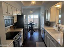 Bright kitchen featuring white cabinetry, modern appliances, and an adjacent dining area at 2905 E Montecito Ave, Phoenix, AZ 85016