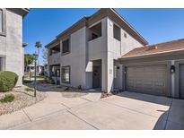 Two-story condo features neutral stucco, tile roof, two car garage, and well-manicured landscaping at 7401 W Arrowhead Clubhouse Dr # 2045, Glendale, AZ 85308