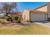 Inviting single-story home with a terracotta-tiled roof, lush lawn and mature landscaping enhancing curb appeal at 13828 S 42Nd St, Phoenix, AZ 85044