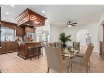 Bright dining room featuring a glass table and seating for eight adjacent to the kitchen island at 1614 W Beaubien Dr, Phoenix, AZ 85027