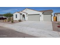 Charming single-story home featuring a three car garage and desert landscaping at 35680 W Mallorca Ave, Maricopa, AZ 85138