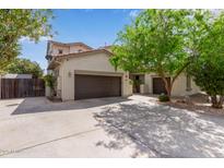 A tan home featuring a 3-car garage with a large driveway and desert landscaping at 3797 E Taurus Pl, Chandler, AZ 85249