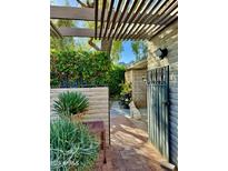 Tranquil courtyard with mature plants, mountain views, and a charming brick pathway at 4800 N 68Th St # 104, Scottsdale, AZ 85251