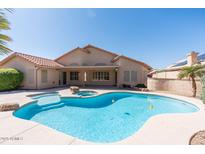 Inviting backyard featuring a sparkling pool, spa, and covered patio, perfect for relaxation and entertaining at 7910 W Adobe Dr, Glendale, AZ 85308