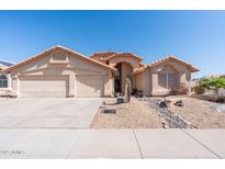 Charming single-story home with a well-maintained desert landscape and a spacious three-car garage at 7910 W Adobe Dr, Glendale, AZ 85308