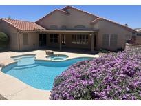 Beautiful backyard pool and patio with desert landscaping and a covered outdoor seating area at 7910 W Adobe Dr, Glendale, AZ 85308