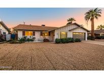 Charming single-story home featuring desert landscaping, a two-car garage and a beautiful sunset at 1015 E Concorda Dr, Tempe, AZ 85282