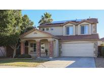 Charming two-story home featuring a tile roof, brick accents, and a well-manicured front yard at 15153 W Riviera Dr, Surprise, AZ 85379