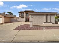 Two-story home featuring a balcony, stucco exterior, and a well-manicured front yard and long driveway at 1810 W Kiowa Cir, Mesa, AZ 85202