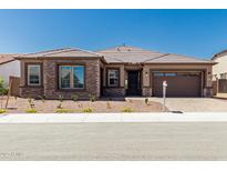 Beautiful single-story home featuring stone accents, a tile roof, and a well-manicured front yard at 20261 W Monterey Way, Buckeye, AZ 85396