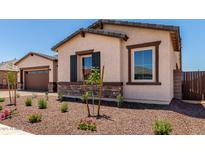 Charming single-story home featuring stucco siding, stone accents, and a well-manicured front yard at 20273 W Monterey Way, Buckeye, AZ 85396