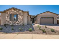 Charming single Gathering home featuring a stone facade, brick driveway, and well-maintained landscaping at 21949 E Twin Acres Dr, Queen Creek, AZ 85142