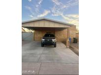 Exterior shot of a home with a carport showing a front view of the car parked beneath it at 3133 W Polk St, Phoenix, AZ 85009