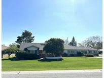 Charming single-story home with mature trees and lush green lawn at 511 W Ocotillo Rd, Phoenix, AZ 85013