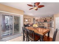 Inviting dining area with wood table, tile flooring, and a view extending to the living area and sliding glass door at 12050 N Panorama Dr # 104, Fountain Hills, AZ 85268
