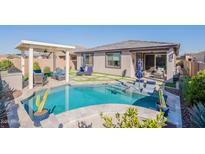 Inviting backyard oasis with a sparkling pool, lounge area, and charming pergola for outdoor relaxation at 12117 W Luxton Ln, Avondale, AZ 85323