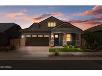 Charming single-Gathering home featuring stone accents, a brick driveway, and a perfectly manicured front lawn at 23146 E Canary Way, Queen Creek, AZ 85142