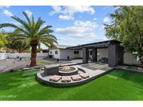 A spacious backyard with a modern fire pit and seating area, perfect for outdoor entertaining at 2818 E Malapai Dr, Phoenix, AZ 85028