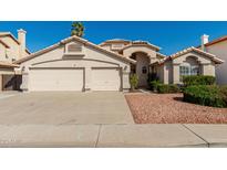 Charming single-story home with a well-maintained front yard and a three-car garage at 654 W Natal Cir, Mesa, AZ 85210