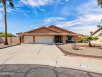 Charming single-story home featuring a three-car garage, desert landscaping, and a well-maintained yard at 7726 W Cameron Dr, Peoria, AZ 85345