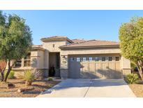 Charming single-story home featuring a well-manicured yard and a two-car garage with decorative windows at 13068 W Mine Trl, Peoria, AZ 85383
