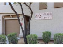View of building number 42 with desert landscaping and garage at 19700 N 76Th St # 1124, Scottsdale, AZ 85255