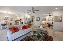 Bright open living room with comfortable seating, ceiling fan, and seamless flow to kitchen and dining at 19700 N 76Th St # 1124, Scottsdale, AZ 85255