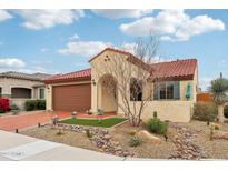 Charming single-story home featuring a desert landscape, red tile roof, and a welcoming arched entrance at 27467 W Osprey Dr, Buckeye, AZ 85396