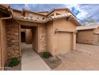 Charming townhome featuring a private garage, stone accents, and neutral stucco exterior at 29120 N 22Nd Ave # 205, Phoenix, AZ 85085