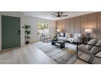Inviting living room with paneled wall, stylish seating, a large window, and a green door at 3207 W Royal Palm Rd, Phoenix, AZ 85051