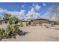 Attractive single-story home with a brick facade, desert landscaping, and a walled courtyard at 7131 E Cholla St, Scottsdale, AZ 85254
