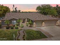 Charming single-story home with manicured lawn, lush landscaping, and a spacious three-car garage at 8260 W Cielo Grande Ave, Peoria, AZ 85383