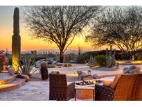 Inviting backyard featuring a cozy fire pit, desert landscaping, and stunning mountain views at sunset at 10067 E Santa Catalina Dr, Scottsdale, AZ 85255