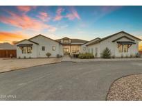 Stunning exterior of a white farmhouse with black trim and a circular driveway at 35150 N Bell Rd, Queen Creek, AZ 85144