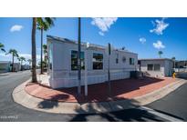 The exterior of this manufactured home boasts a corner lot and vibrant palm trees at 39 Iron Ore Dr, Apache Junction, AZ 85119