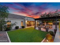 Beautiful backyard featuring green grass, a covered patio, an outdoor kitchen, and an amazing sunset at 610 W Tonto Dr, Chandler, AZ 85248