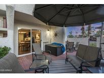 Cozy outdoor patio with furniture, a sun umbrella, and sliding glass doors for indoor/outdoor living at 7350 N Via Paseo Del Sur -- # N108, Scottsdale, AZ 85258