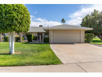 Charming single-story home featuring a well-maintained lawn and a two-car garage at 10763 W Cinnebar Ave, Sun City, AZ 85351