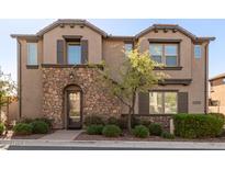 Charming two-story townhome featuring a stone facade, manicured landscaping, and a welcoming entrance at 1153 E Muirwood Dr, Phoenix, AZ 85048
