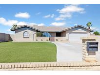 Charming single-story home featuring a well-kept artificial lawn, desert landscaping, and a two-car garage at 16824 N 38Th Dr, Phoenix, AZ 85053
