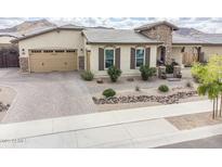 Charming single-story home featuring desert landscaping, stone accents, and a paver driveway leading to a two-car garage at 20961 E Stacey Rd, Queen Creek, AZ 85142
