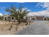 Stunning desert home featuring stone accents, a paver driveway, and beautiful desert landscaping with cacti at 7498 E Whisper Rock Trl, Scottsdale, AZ 85266