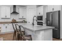 Modern kitchen features a large island with bar seating, stainless steel appliances, and white cabinets at 9718 E Radioactive Dr, Mesa, AZ 85212