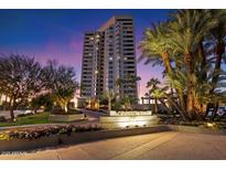 Stunning high-rise condo building in a tropical setting with lush landscaping and vibrant evening sky at 1040 E Osborn Rd # 203, Phoenix, AZ 85014