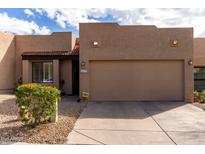 Charming single-story home with a two-car garage, desert landscaping, and a red tiled entry roof at 11779 E Becker Ln, Scottsdale, AZ 85259