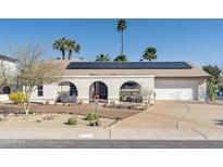 Charming home featuring an arched porch, solar panels, desert landscaping, and a two-car garage at 2346 E Lupine Ave, Phoenix, AZ 85028