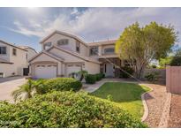 Inviting two-story home with a well-manicured lawn, mature tree, and three-car garage at 3524 E Derringer Way, Gilbert, AZ 85297