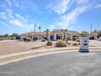 Stunning single-story home with a circular driveway, desert landscaping, and a red tile roof at 3943 E Omega Cir, Mesa, AZ 85215