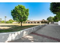 Expansive property with a lush green lawn and large, well-manicured tree, offering a serene and inviting outdoor space at 5501 E Camelback Rd, Phoenix, AZ 85018